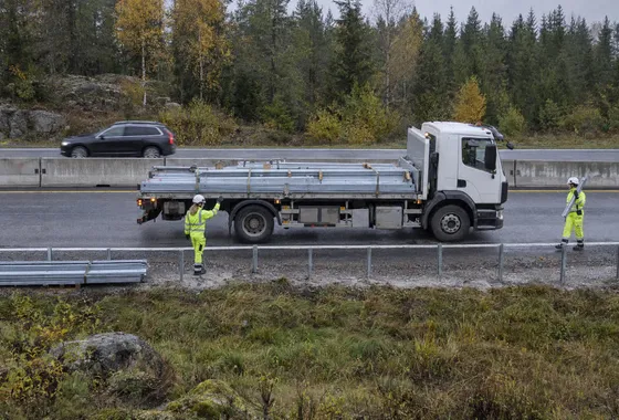Lastbil backar med backvakt bredvid